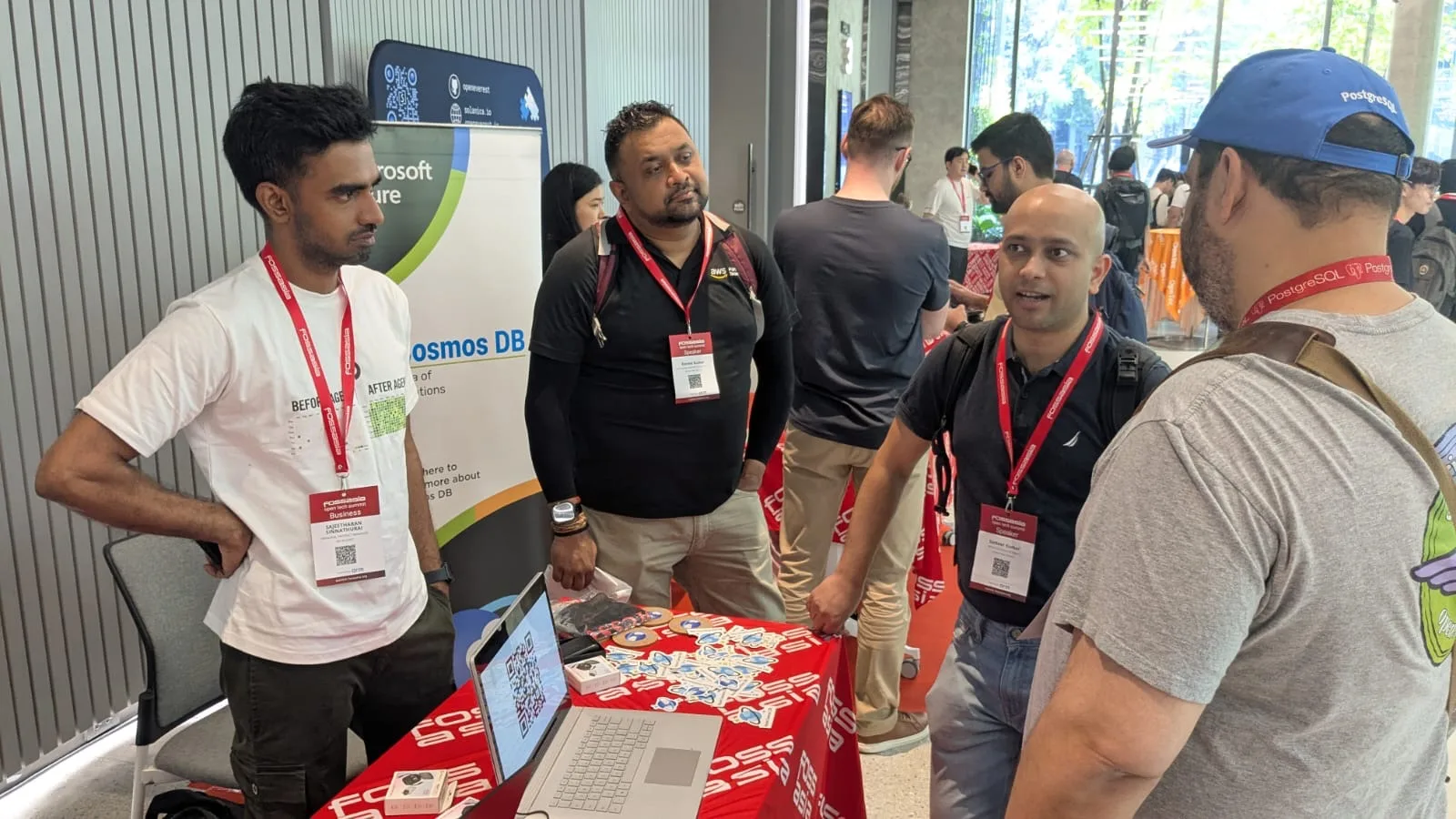 Attendees talking with a representative at the Azure Cosmos DB booth during FOSSASIA Summit, discussing cloud databases and developer tools.