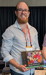 A CppCon attendee holding a LEGO prize
