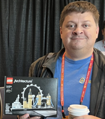 A CppCon attendee holding a LEGO prize