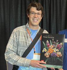 A CppCon attendee holding a LEGO prize