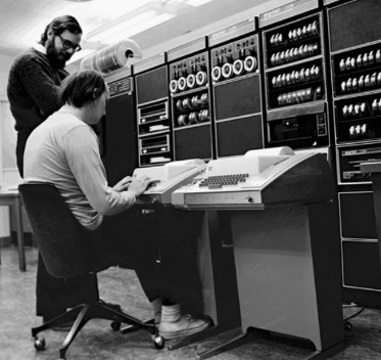 Ken Thompson and Dennis Richie (standing) working on a DEC PDP-11 via teletype (notice no electronic display)